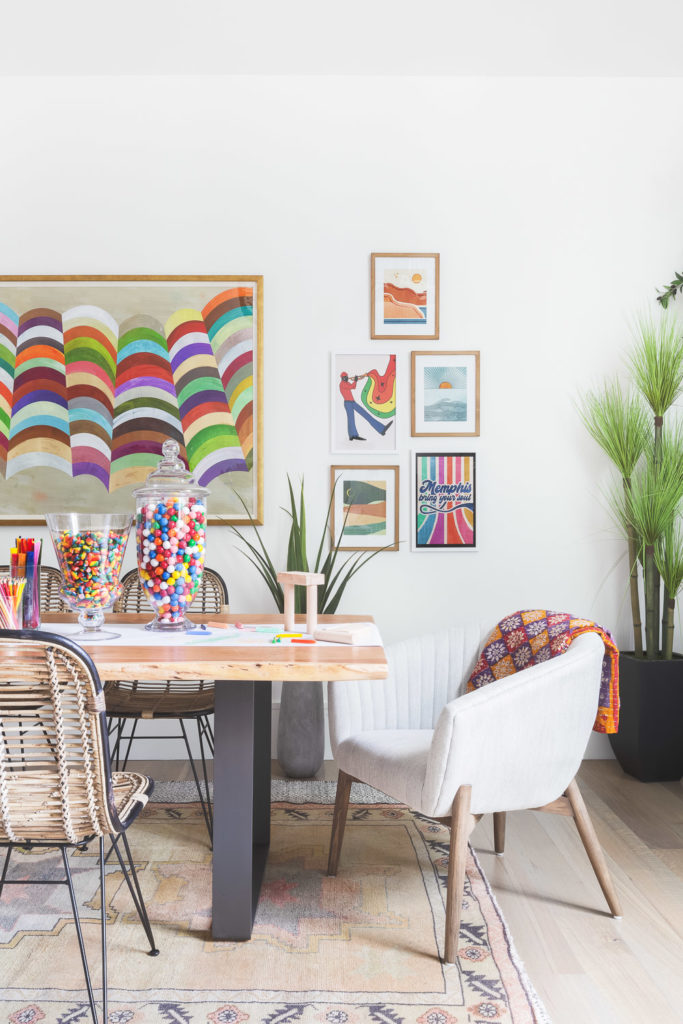 Eclectic dining area with mismatched chairs and vibrant art pieces.