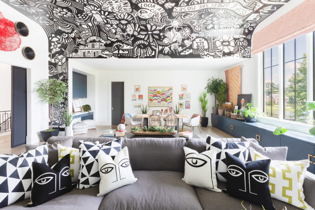 Living area with black and white patterns and a plush gray sofa.