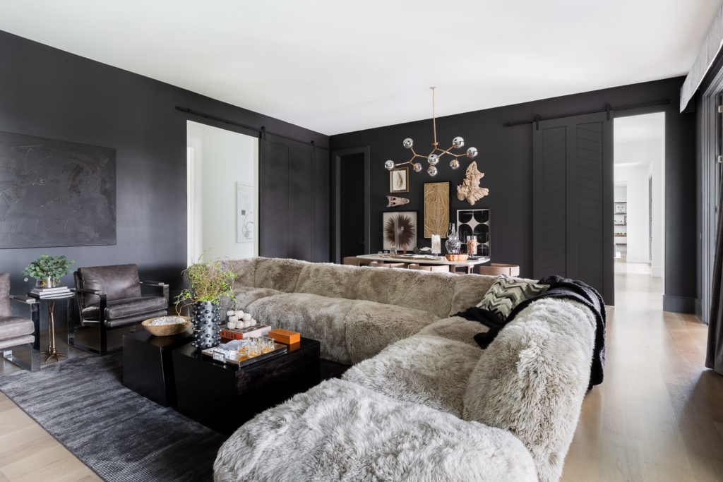 Seating area with dark accent wall, table, chairs, and pendant light.