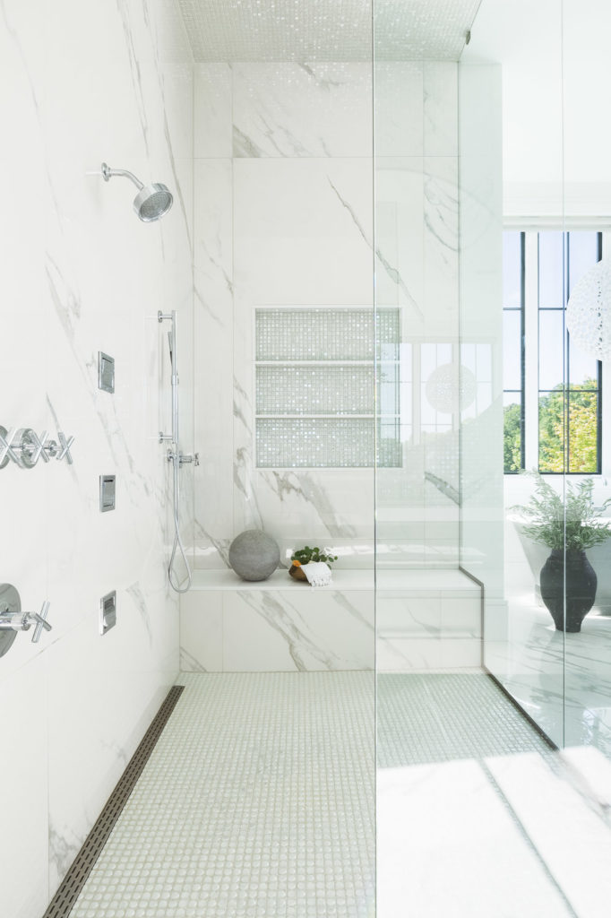 Luxurious marble bathroom with spa-like shower and mosaic-tiled wall.