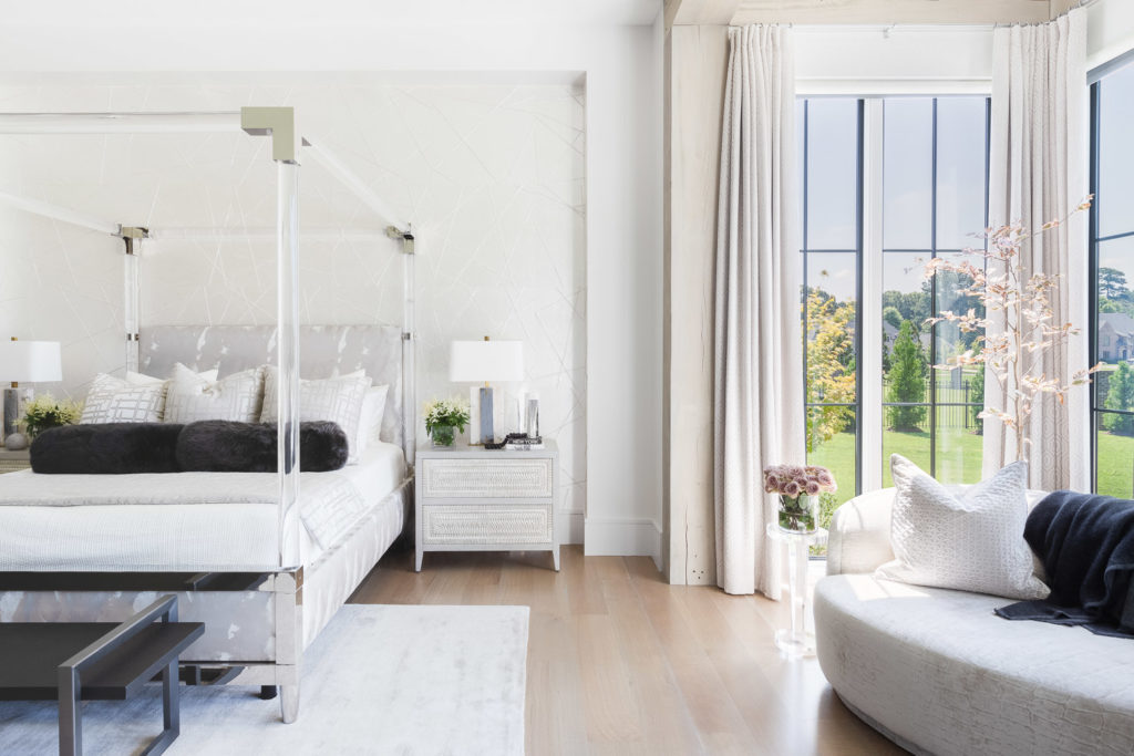 Luxurious minimalist bedroom with wooden flooring and outdoor view.