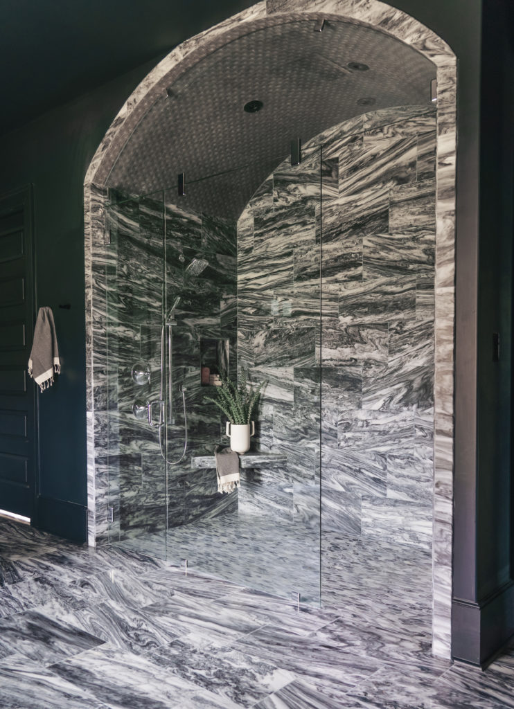 Image showcasing a luxurious shower with marble-inspired tile design and intricate patterns.