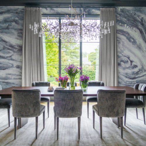 Luxurious dining area with tall window view and stunning chandelier.