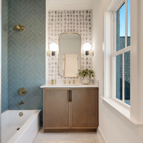 Modern Scandinavian bathroom showcasing a herringbone patterned tiled wall.