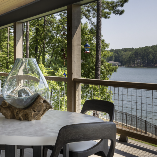 A serene lakeside view with decorated table and chairs for relaxation and leisure.